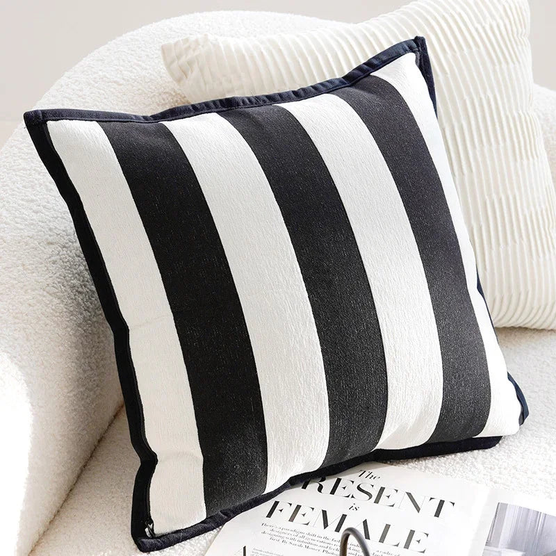 Black and white striped eprolo sofa pillow cover on a white textured couch.