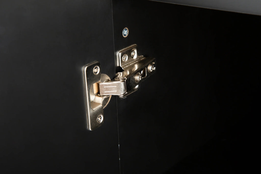 Close-up of a silver metal cabinet hinge installed on a black eprolo kitchen island cabinet.
