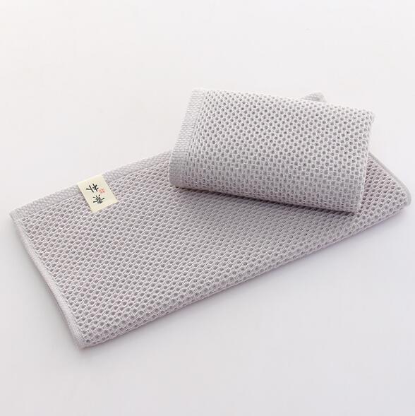Grey waffle weave cotton hand towel by eprolo for bathroom or face care.