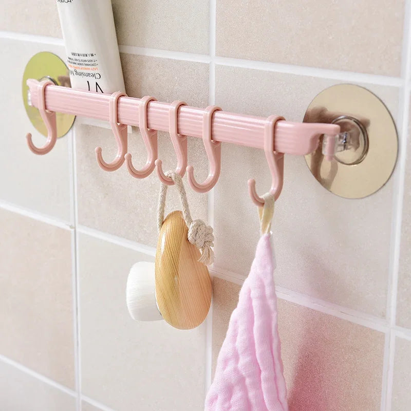 Pink eprolo seamless nail-free adhesive hook strip hanging towels and skincare in a bathroom.