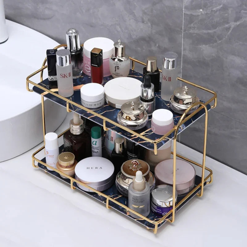 Double-layer golden cosmetic storage rack with blue marble pattern holding various skincare bottles.
