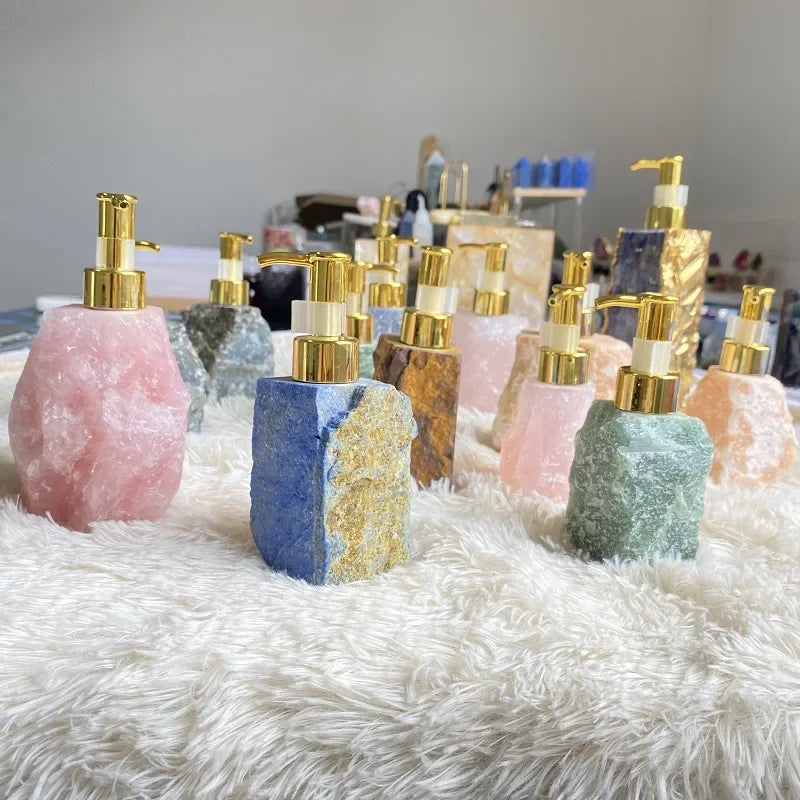 Collection of eprolo natural crystal stone liquid soap dispensers with gold pumps on a white rug