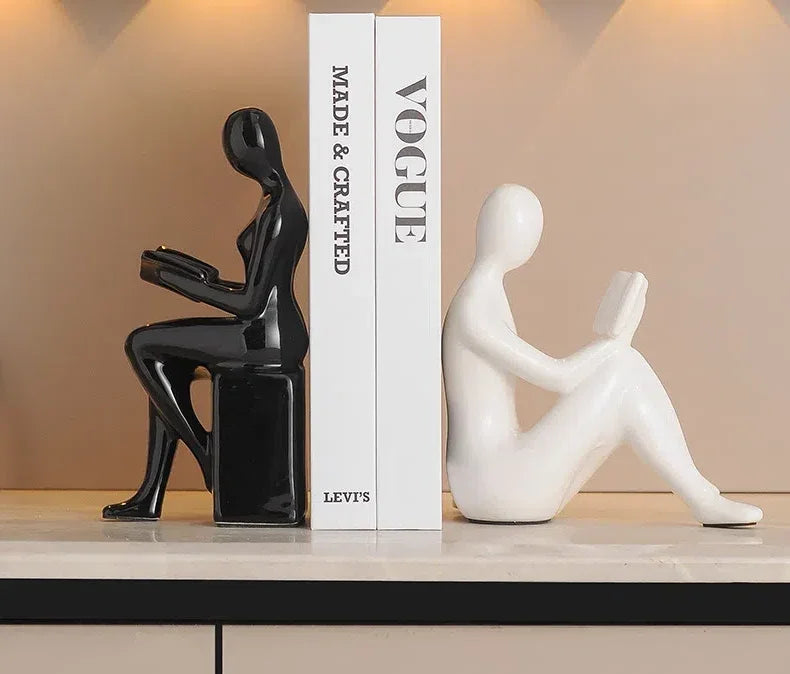 Modern black and white female figure bookends holding books on a shelf by eprolo.