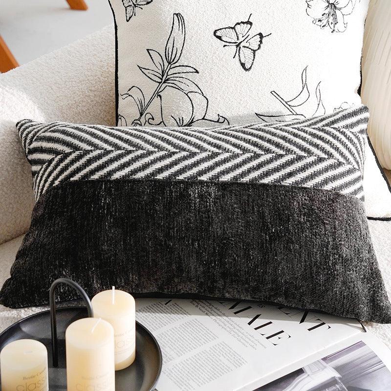 Two decorative sofa pillows with chevron and floral patterns on a white couch.