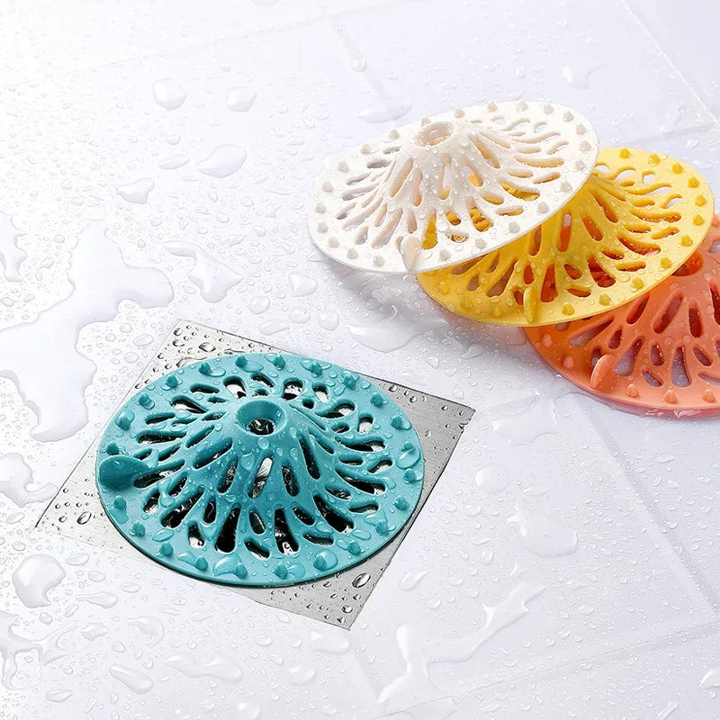 Three eprolo volcano-shaped anti-clogging floor drain covers in teal, white, and yellow.