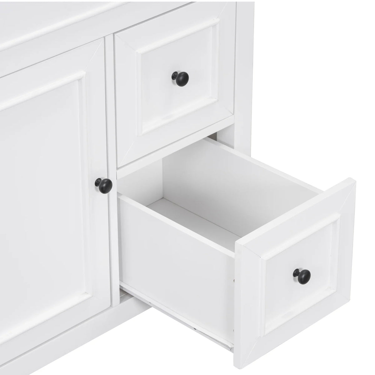 Detail of a white eprolo bathroom vanity cabinet with open drawer and black knobs.