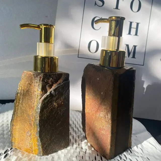 Two eprolo luxury liquid soap dispensers with natural stone bases and gold pump heads.