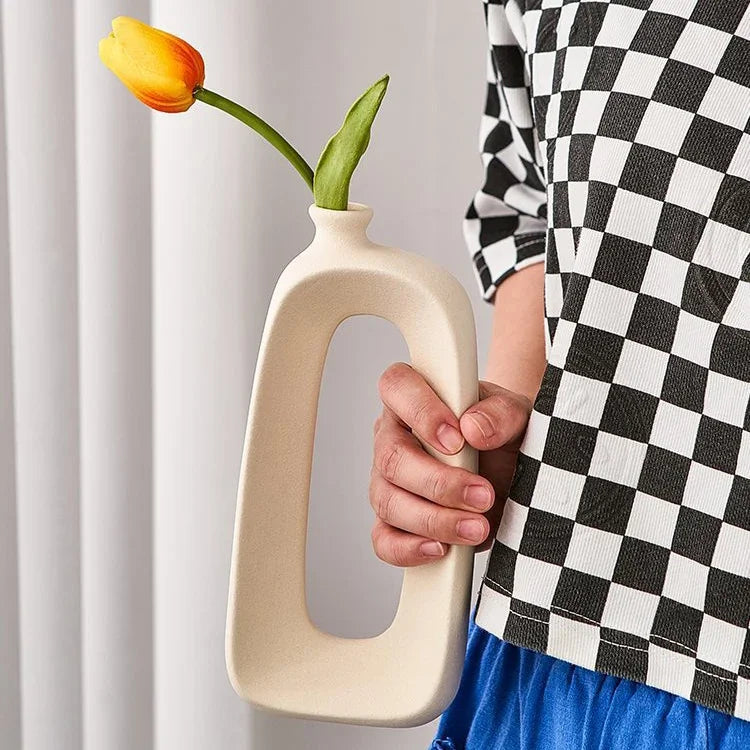 Hand holding a modern eprolo ceramic vase with a yellow tulip decoration