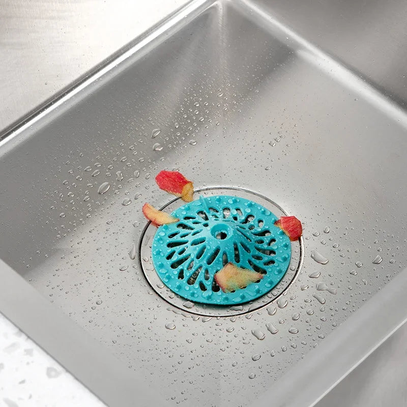 Blue volcano-shaped sink strainer catching food debris in a stainless steel kitchen sink.