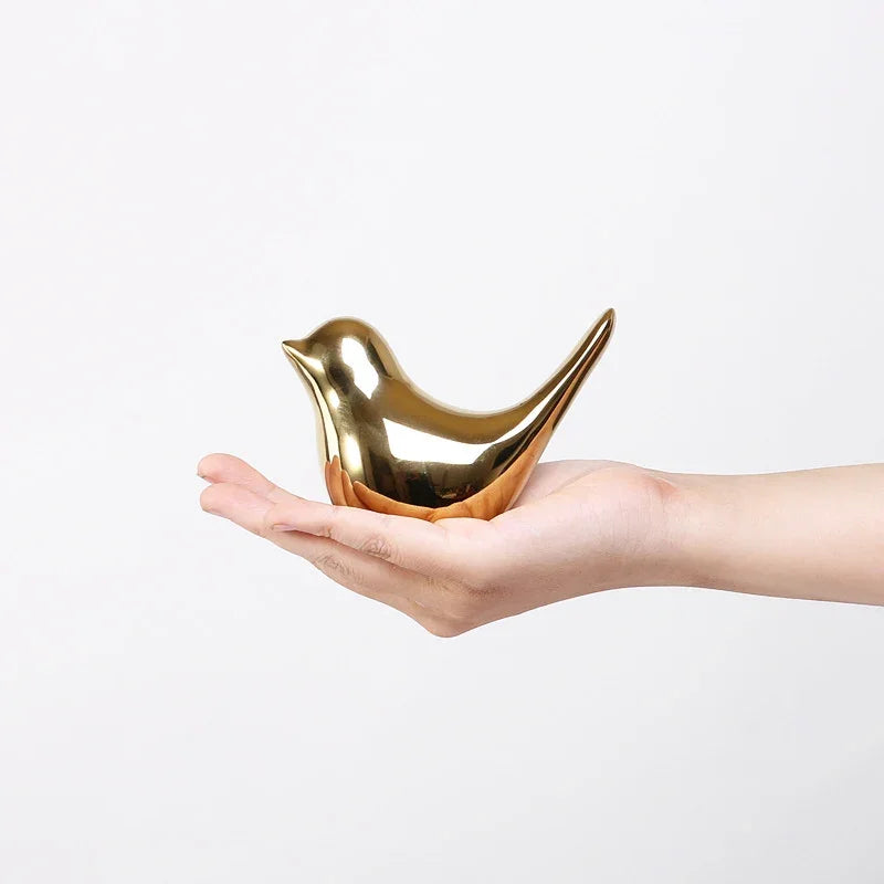 Hand holding a Nordic creative golden ceramic bird craft ornament by eprolo