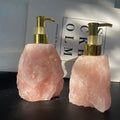Two eprolo natural pink crystal stone liquid soap dispensers with gold pumps.