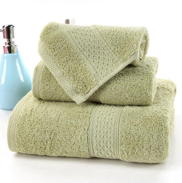 Set of three sage green 100% cotton terry bath towels by eprolo with a blue soap dispenser.