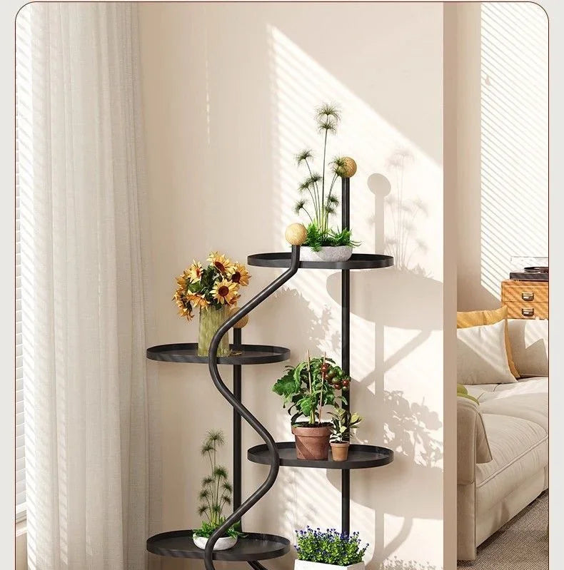 Eprolo black metal floor standing flower rack with various potted plants in a bright living room.