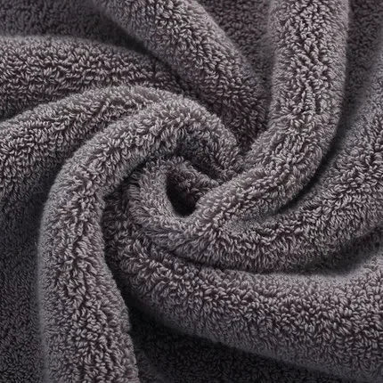 Close-up texture of a thick, grey 100% cotton luxury bath towel.