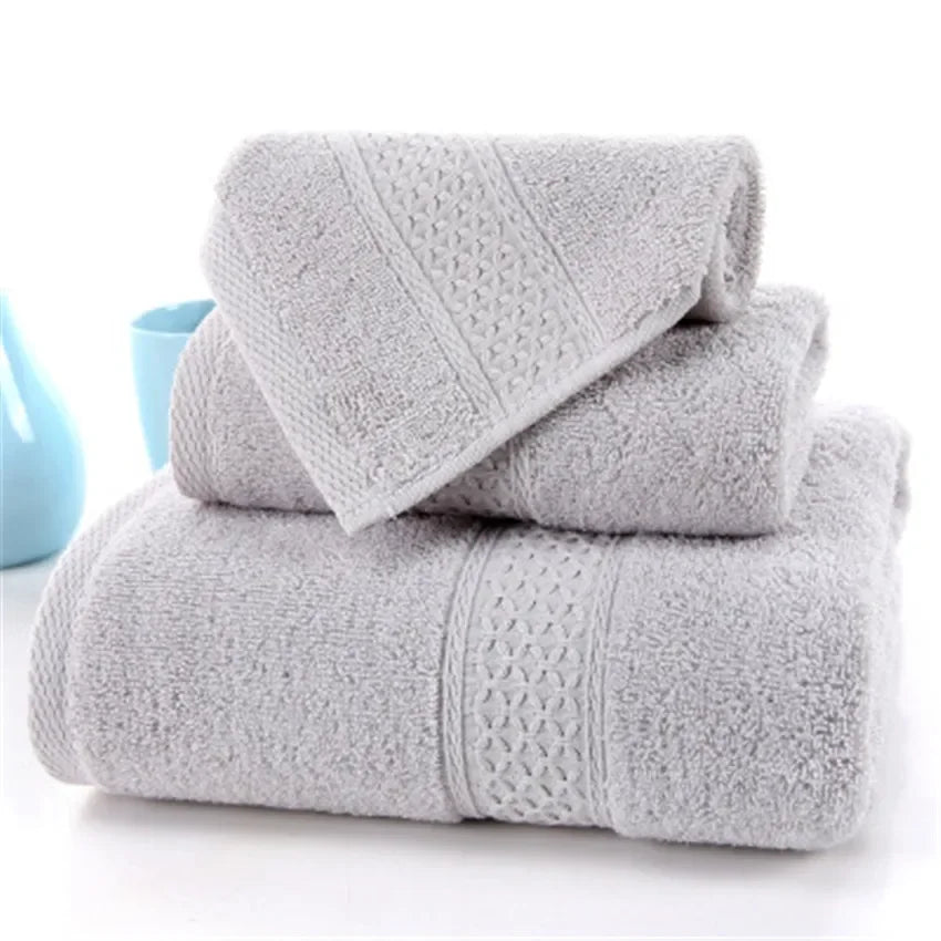 Set of three grey 100% cotton terry bath towels by eprolo stacked on a white surface.