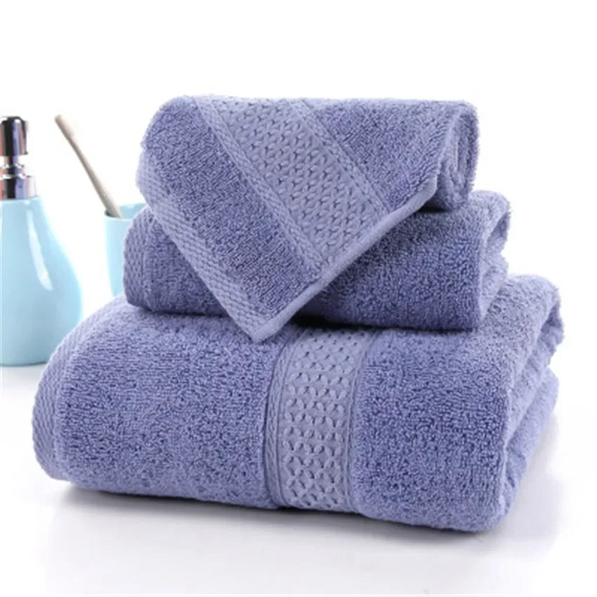 Set of three purple 100% cotton terry bath towels by eprolo stacked in a bathroom setting