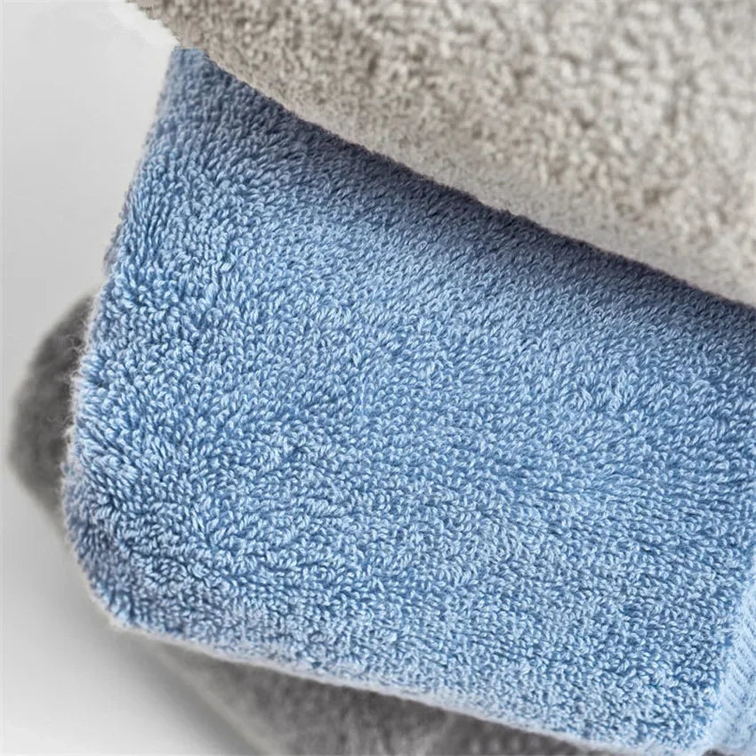 Stack of soft eprolo 100% cotton luxury bath towels in light blue and grey.