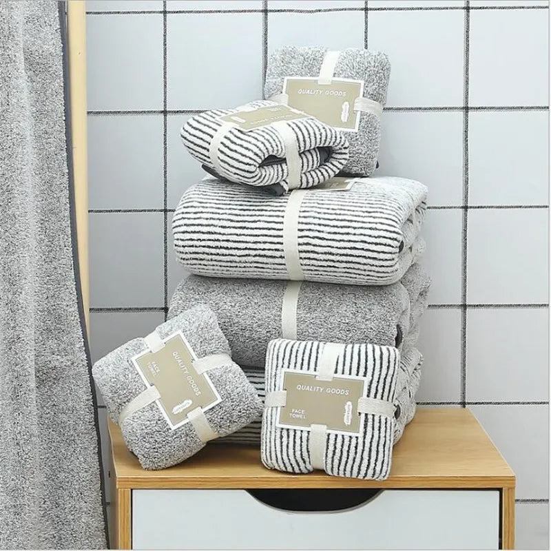 Stack of eprolo bamboo charcoal coral velvet bath and face towels in grey and striped patterns.